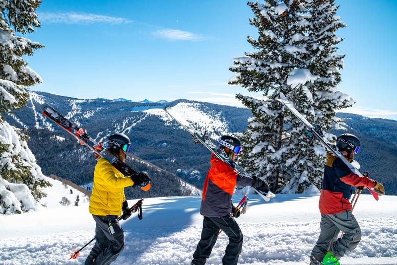 skieur portent leurs ski et marchent dans la neige