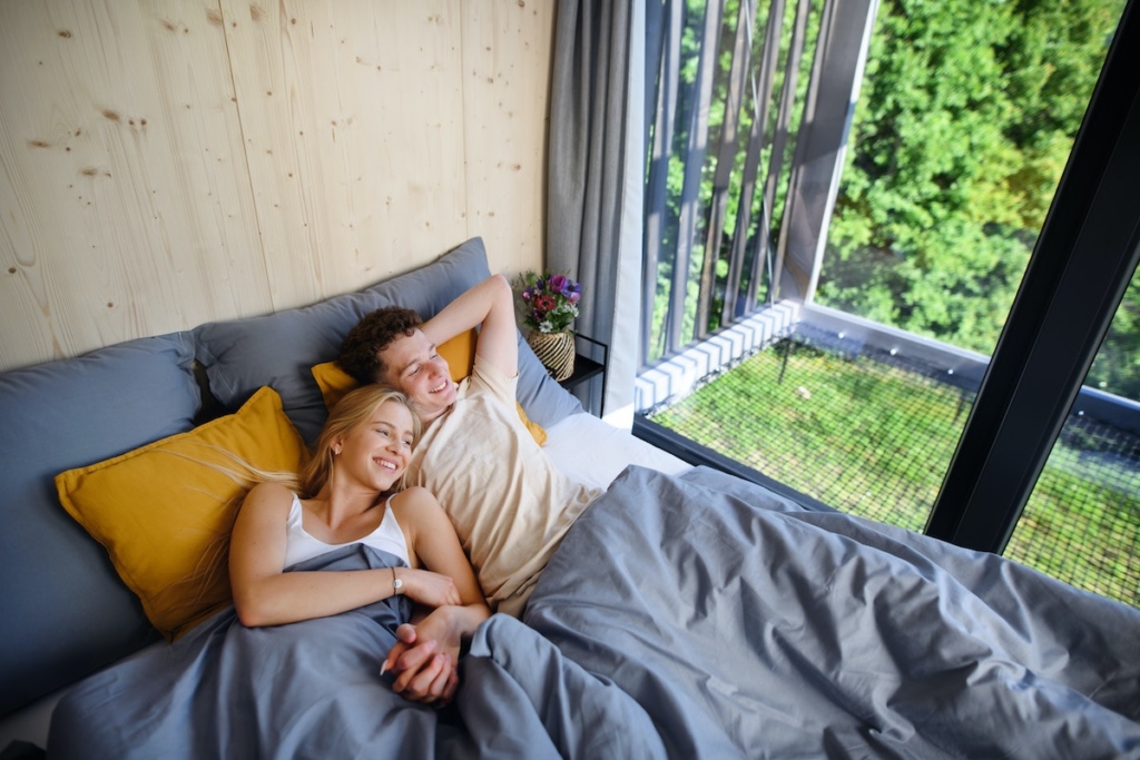 Un couple fait la grasse matinée dans la chambre de son écolodge dans la campagne française